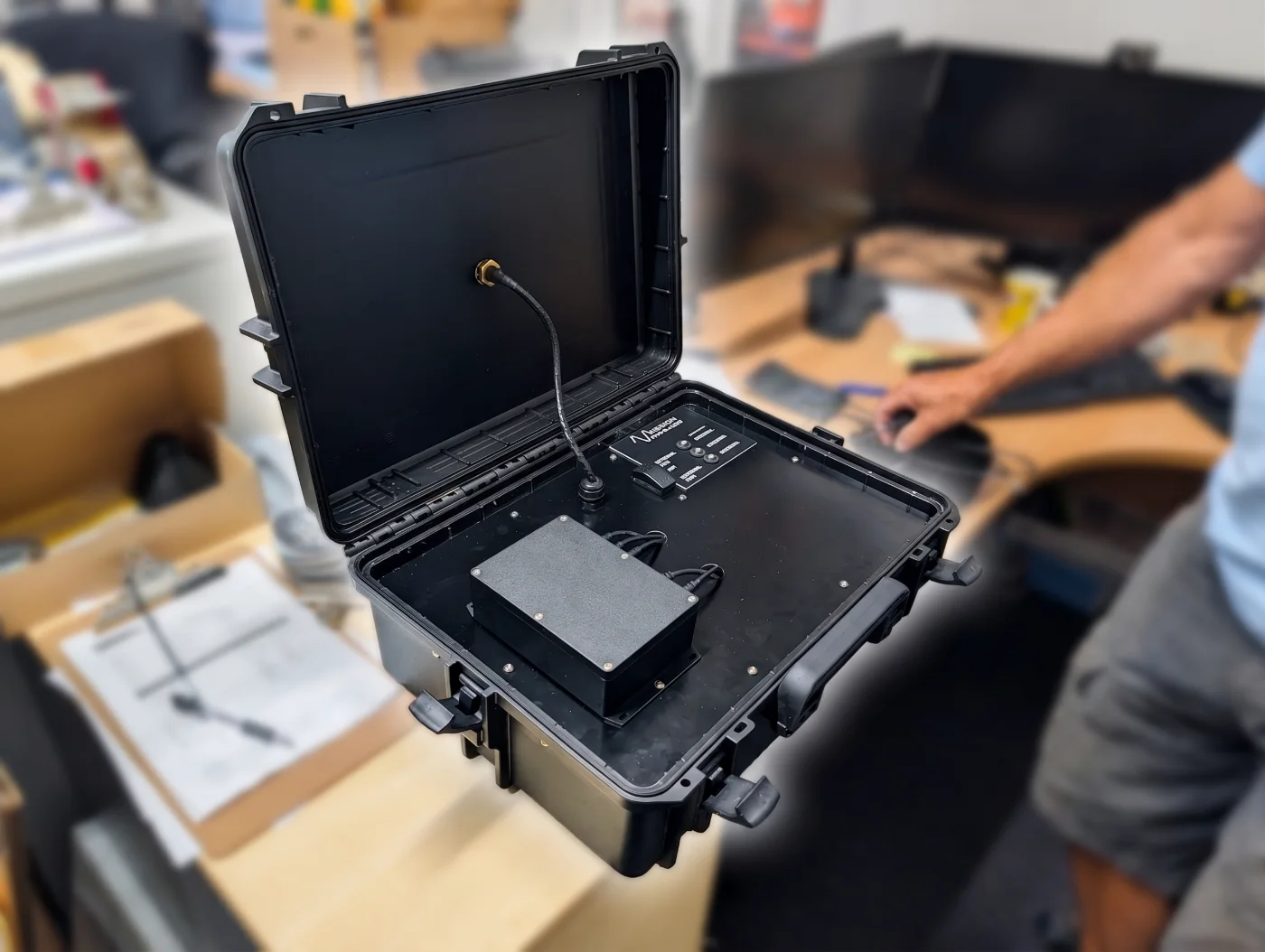 BRNKL Portable case open on the bench, showing the internal recording unit, connected antenna lead and labelled Mission Dynamics status panel