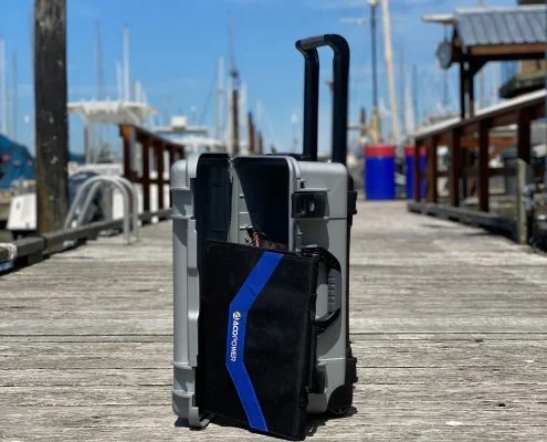 BRNKL Portable case with fold-out solar panel, GPS antenna and PoE camera laid out on a pontoon